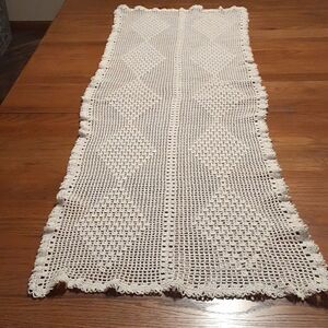Hand crocheted ecru table runner rectangle with lace fringe.